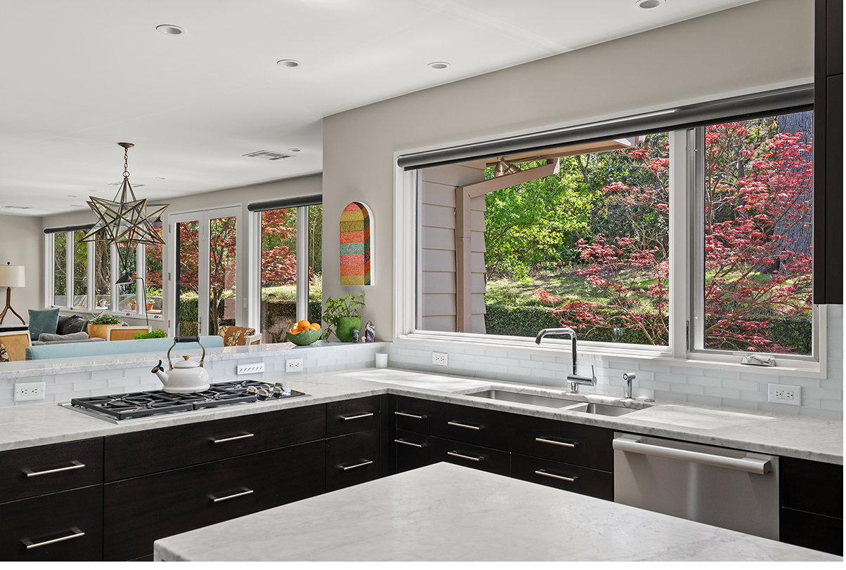 Chef's kitchen with Carrara marble island and Japanese maple view
