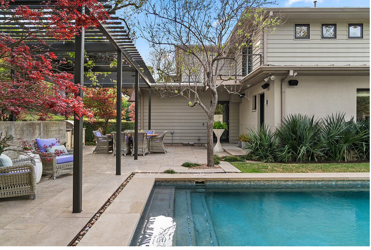 Heated pool and limestone terrace with steel pergola and Japanese maples